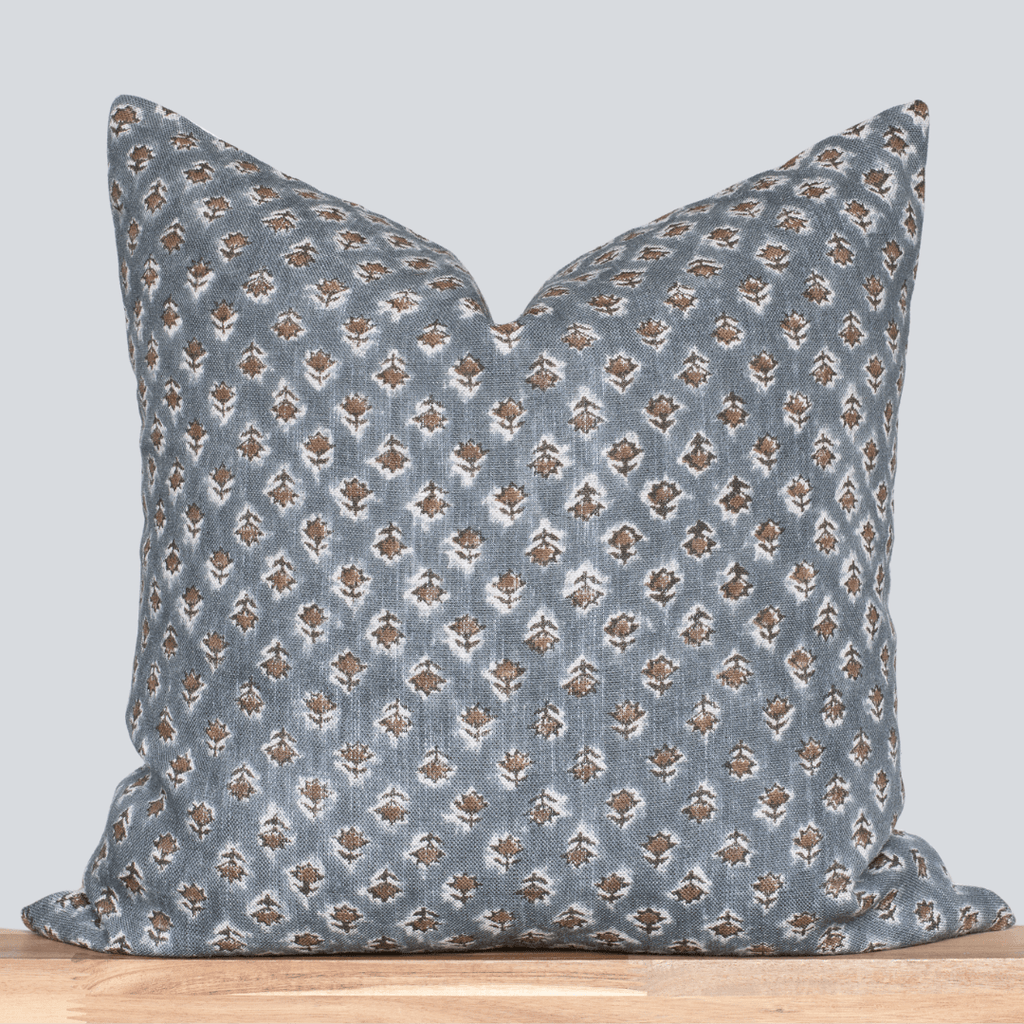 Decorative pillow with a blue and brown pattern on a light gray background
