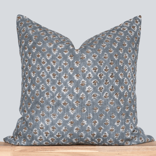 Decorative pillow with a blue and brown pattern on a light gray background